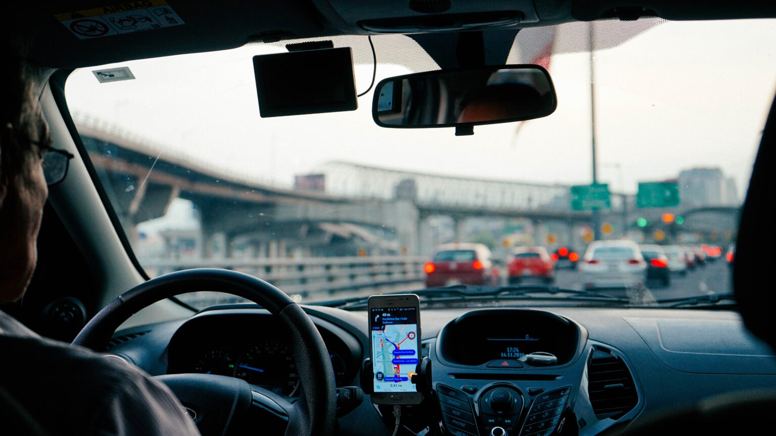 Chauffeur au volant, vue sur la route à travers le pare-brise avec un GPS sur le tableau de bord